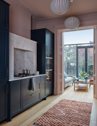 The kitchen in a Kensington house by Kate Guinness designed and made in collaboration with 202 Design opens into the...